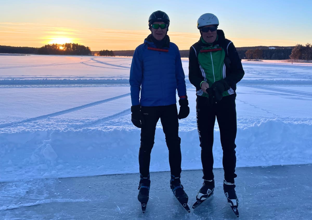 Twee schaatsers op een geveegde baan bij Falun tijdens zonsondergang