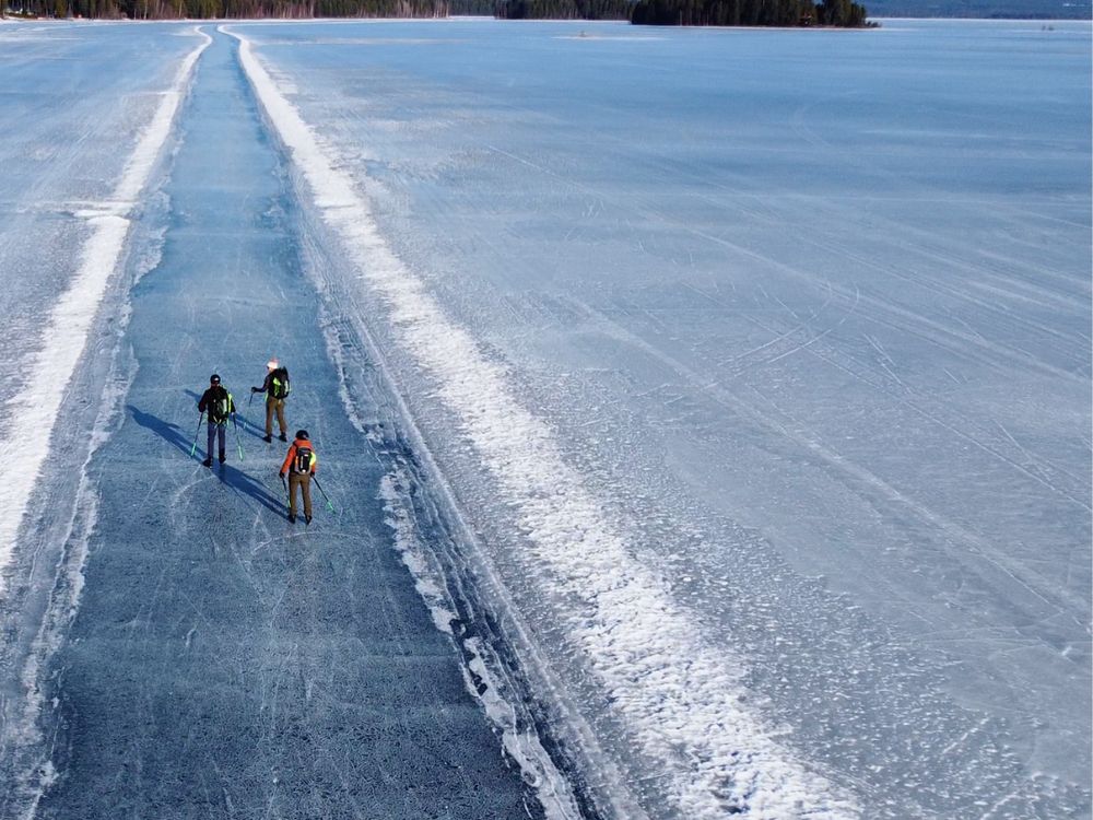 Drie schaatsers op de geveegde baan van zwart ijs op het Orsameer