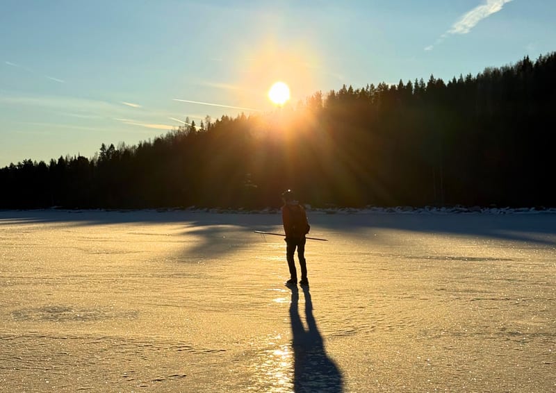 Schaatser in tegenlicht op natuurijs